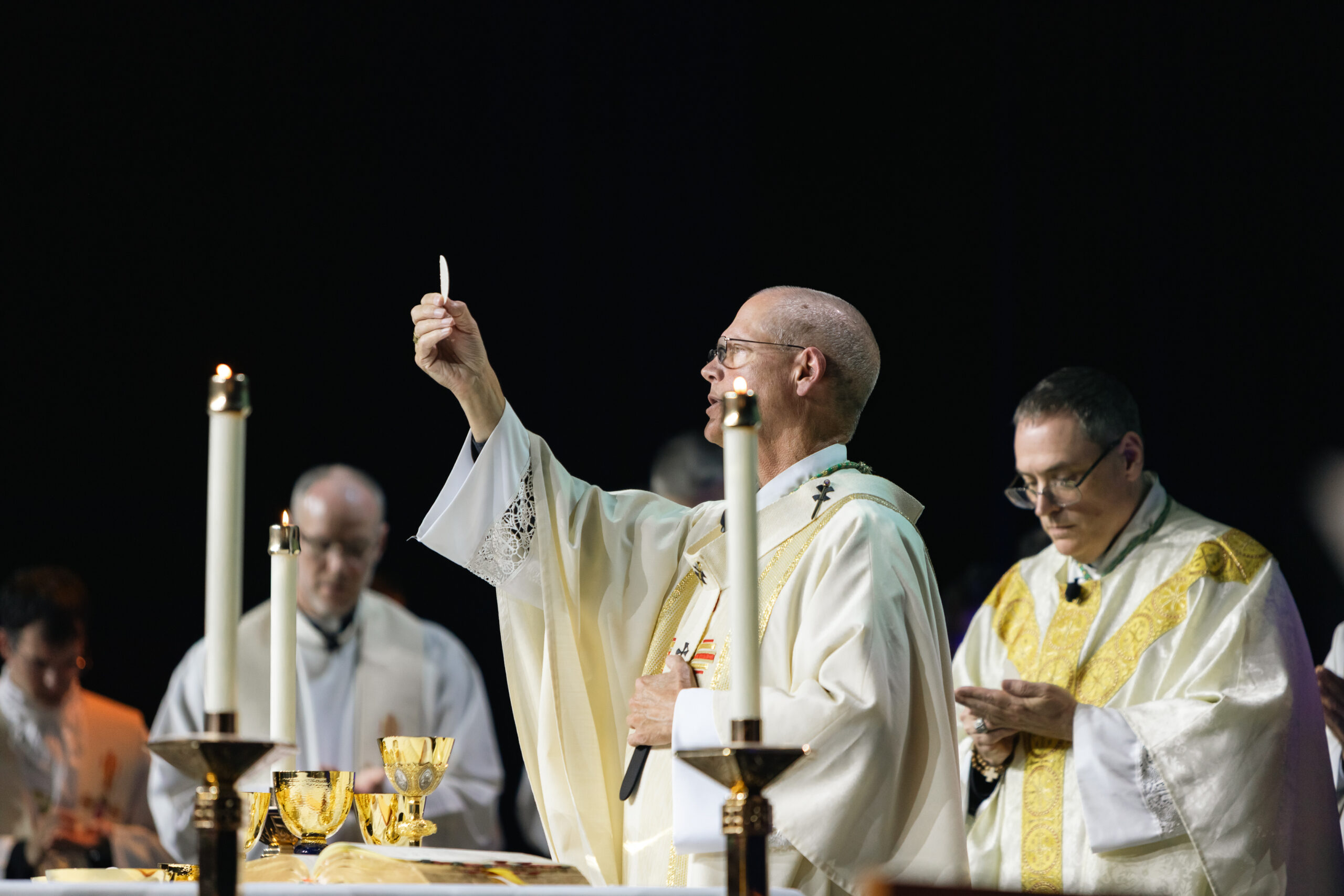 Archbishop Etienne lifts the host during the Consecration at the Mass celebrated at the ASCEND Eucharistic Revival.